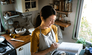 happy woman reading a cookbook