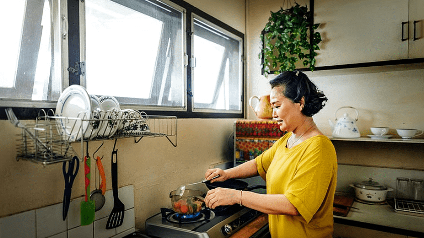 woman wearing yellow top cooking in the kitchen
